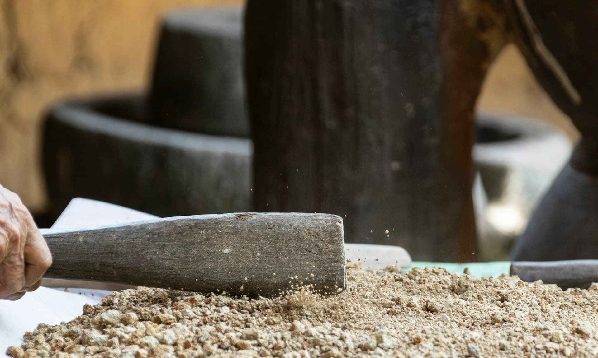Grains being ground by hand with a traditional stone